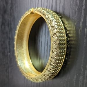 Gold colored texture bangle with hinge closure